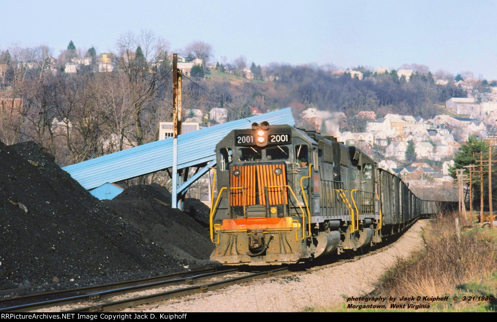 MGA, Monongahela Railway GP38s 2001- 2003 has a northbound loaded coal train at, Morgantown, West Virginia. March 21, 1986.